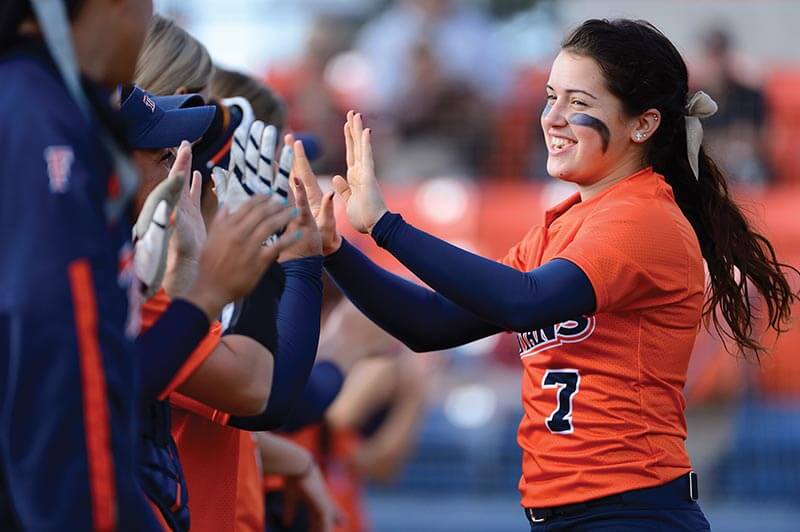 Softball player celebrating with team